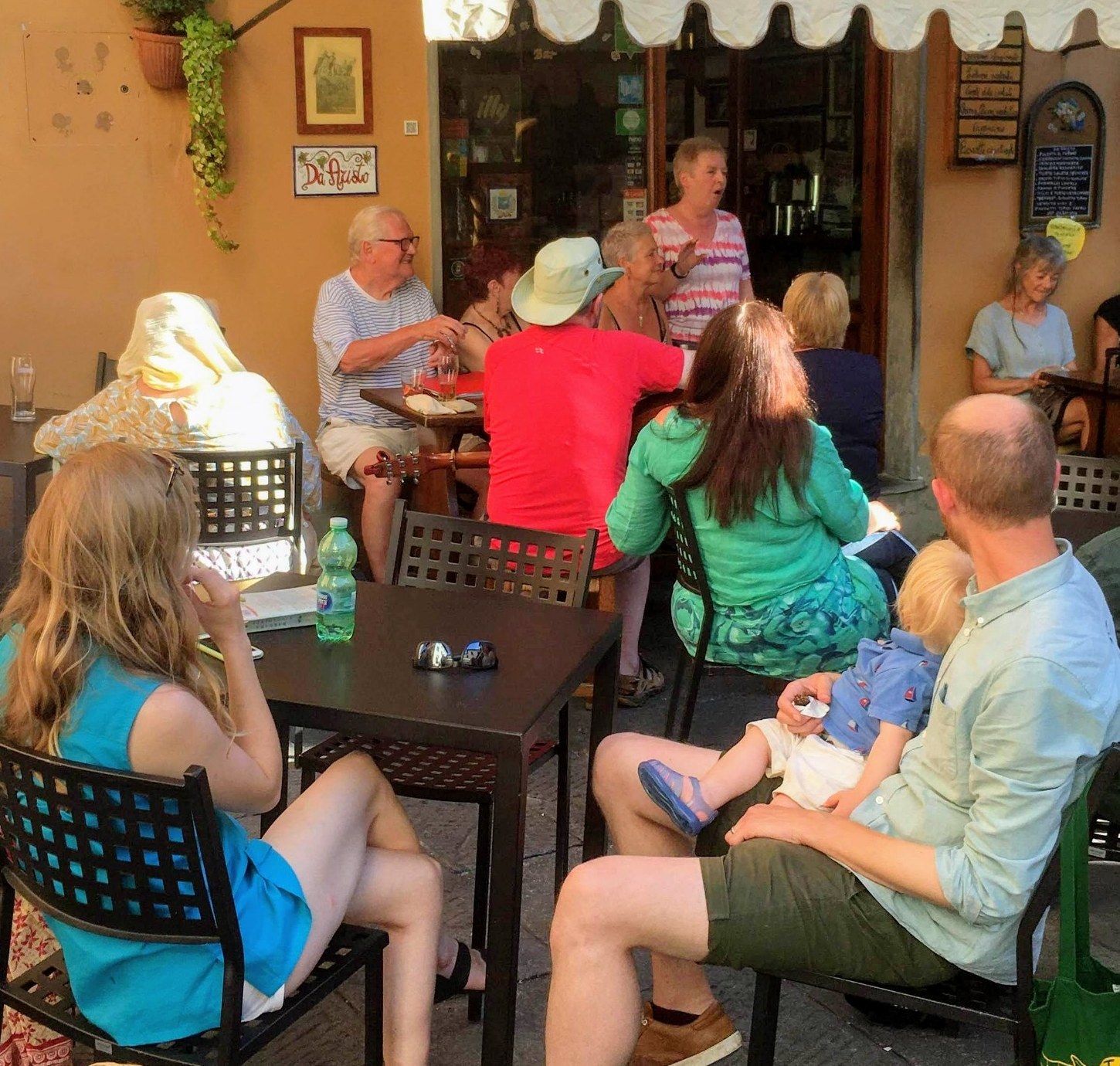 Betty telling stories in an outdoor café with an informal audience gathered around her.